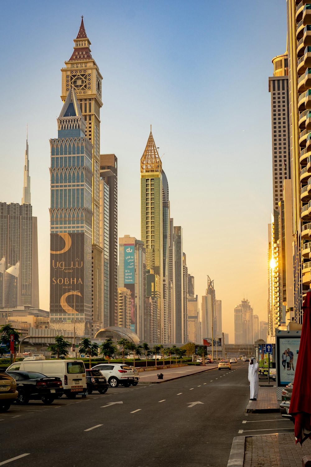 A man in a white thobe on a Dubai street at golden hour